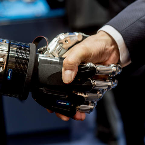 Roboterhand schüttelt Menschenhand